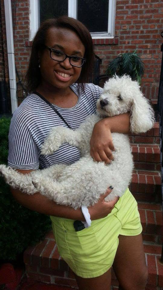 Kyra at 14, holding her friend's white poodle Max on the front stoop